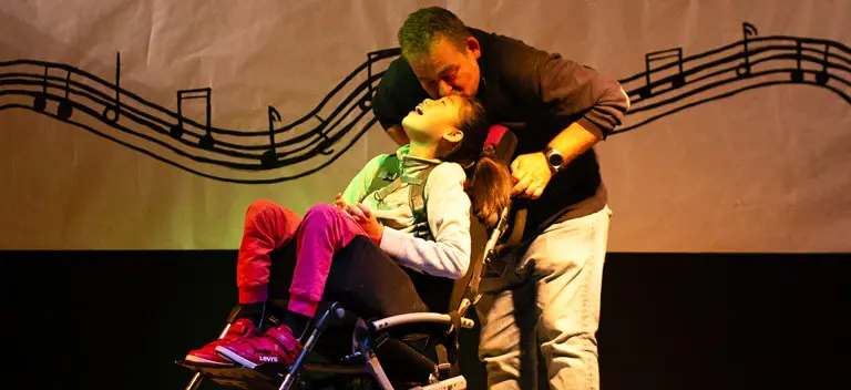 Asociación Mi princesa Rett Sara y su padre, en el escenario, parecen un mundo aparte sostenido por la luz.