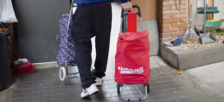 Adrián, con un carrito de la compra repleto de productos y alimentos para niños.