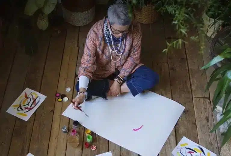 Centro de investigación Ageingnomics Mujer pintando un cuadro durante una actividad artística.