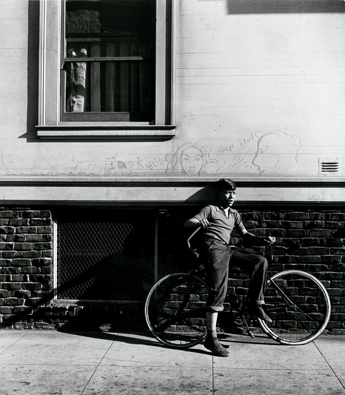 Street boy with bicycle and graffiti