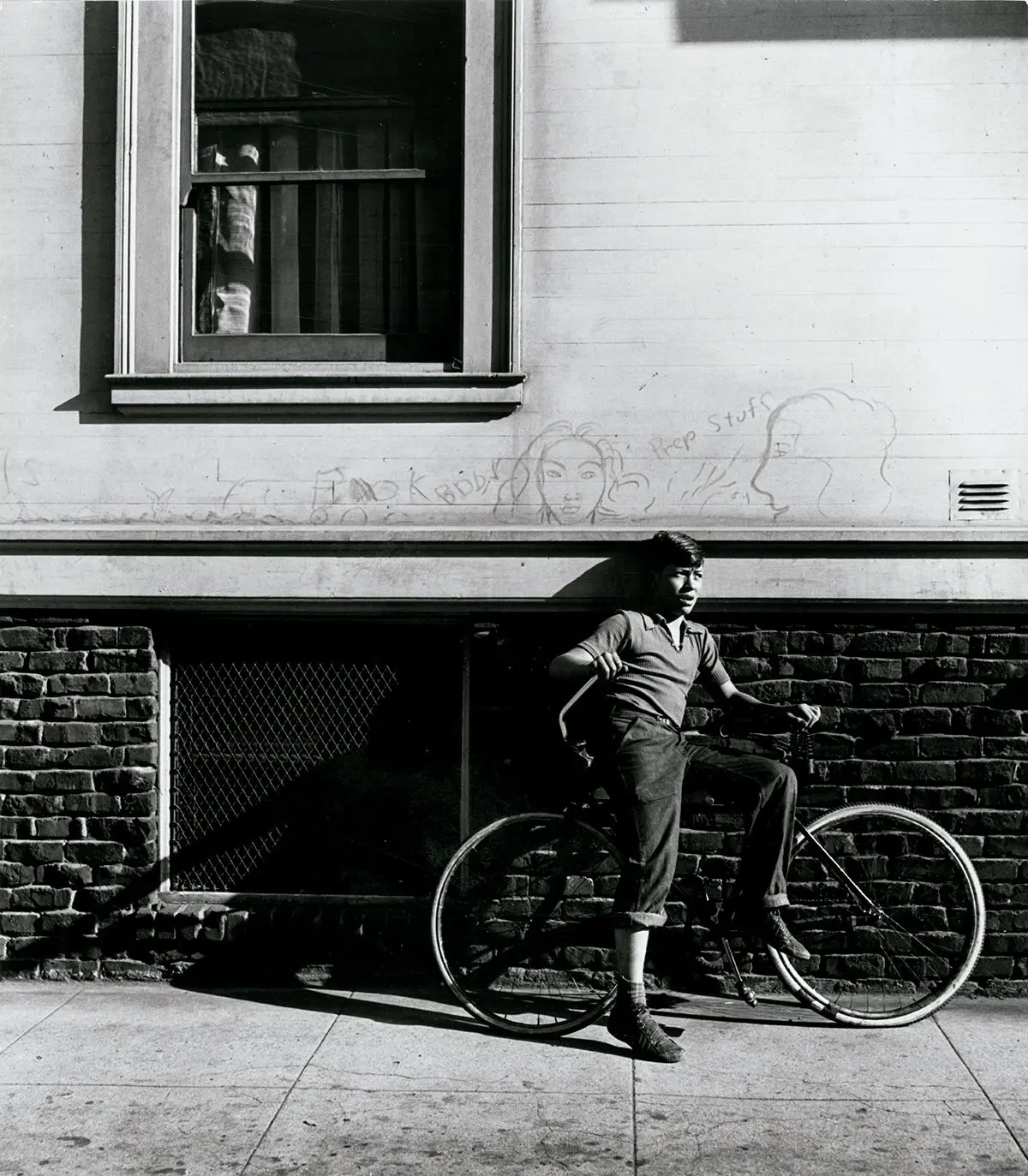 Street boy with bicycle and graffiti