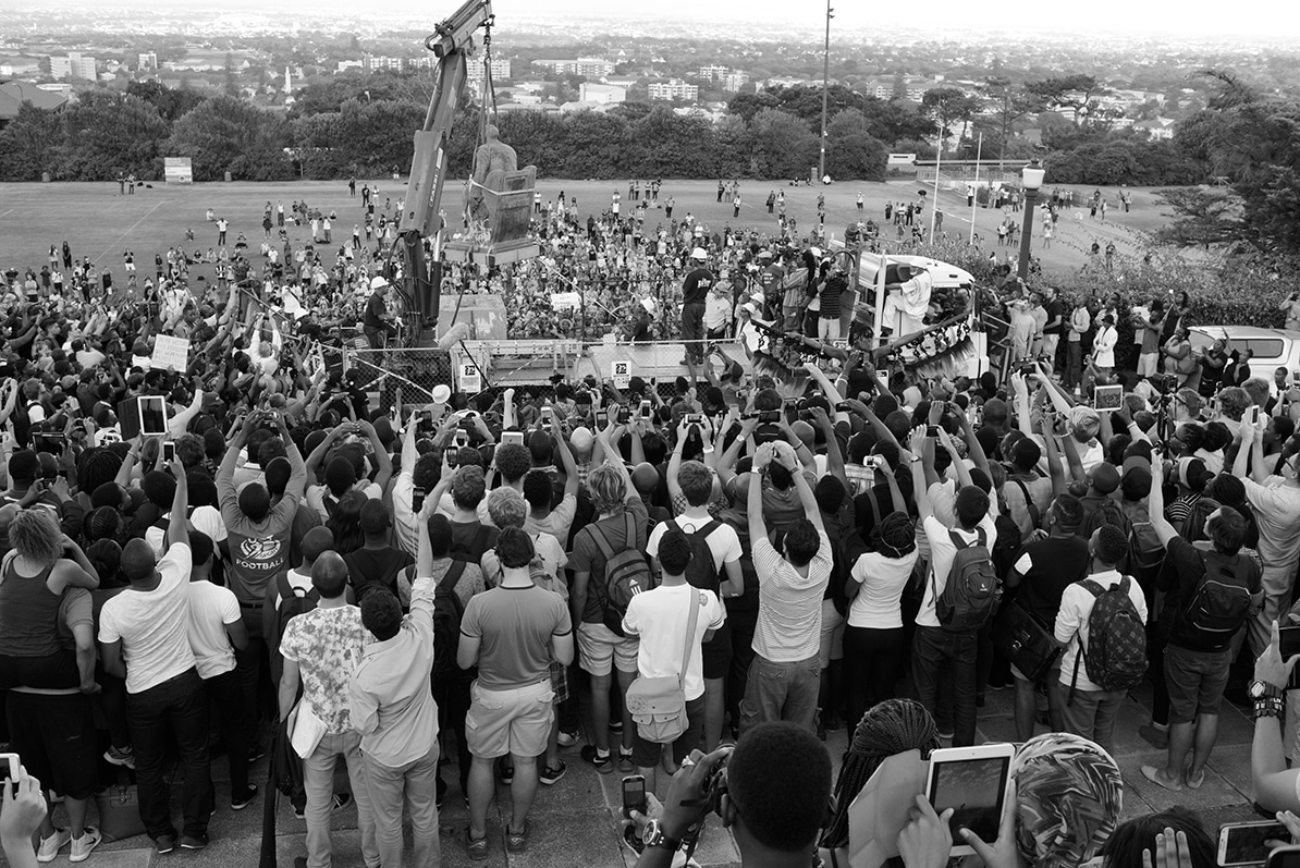 El derrocamiento de Cecil John Rhodes después de arrojar heces humanas contra la estatua y de que la universidad accediera a las demandas de los estudiantes para su retirada, Universidad de Ciudad del Cabo, 9 de abril de 2015