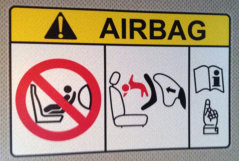 When should you disable the front passenger airbag, and how do you do it?