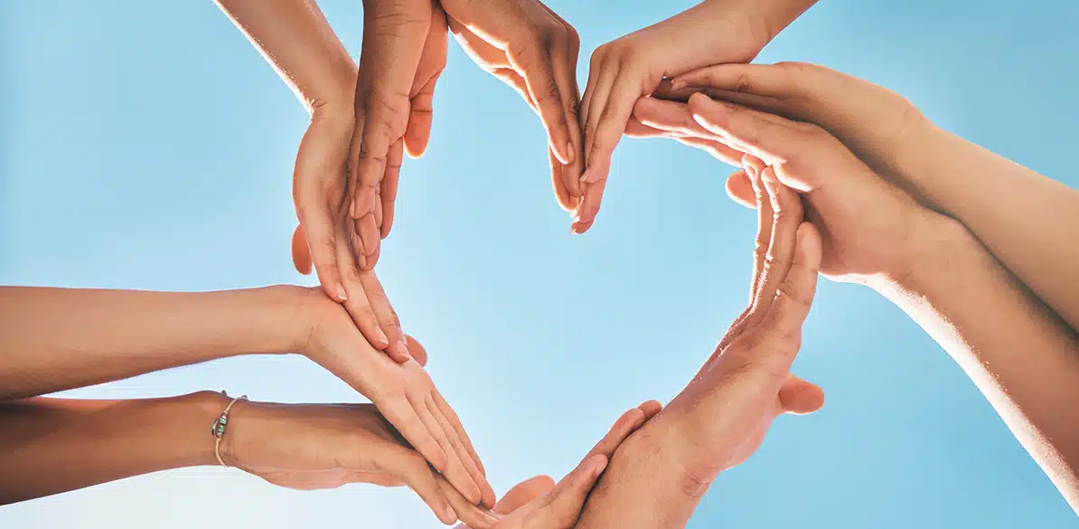 Imagen de manos formando un corazón bajo un cielo claro, simbolizando la solidaridad y unidad. Se celebra el Día Internacional de la Solidaridad Humana, un recordatorio para actuar con empatía y cooperación, contribuyendo al bienestar colectivo y al cambio positivo.