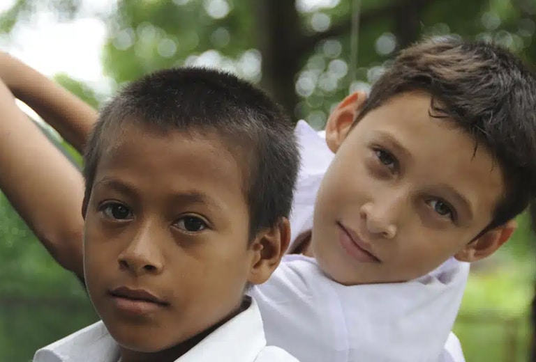Dos niños mirando a cámara durante un proyecto de inclusión social.