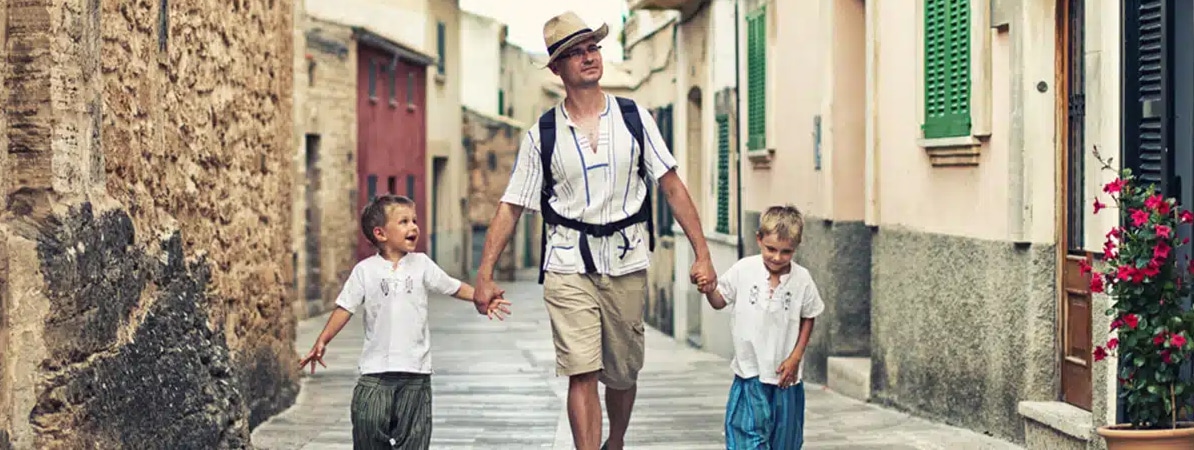 Eventos Hombre paseando con dos niños por una calle de un entorno rural