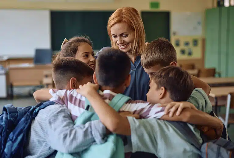 Bienestar en red Docente junto a un grupo de estudiantes en un aula escolar durante una actividad colaborativa