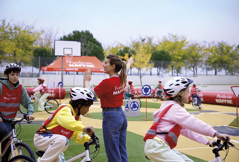 Voluntaria de Fundación Mapfre con niños en una actividad de educación vial