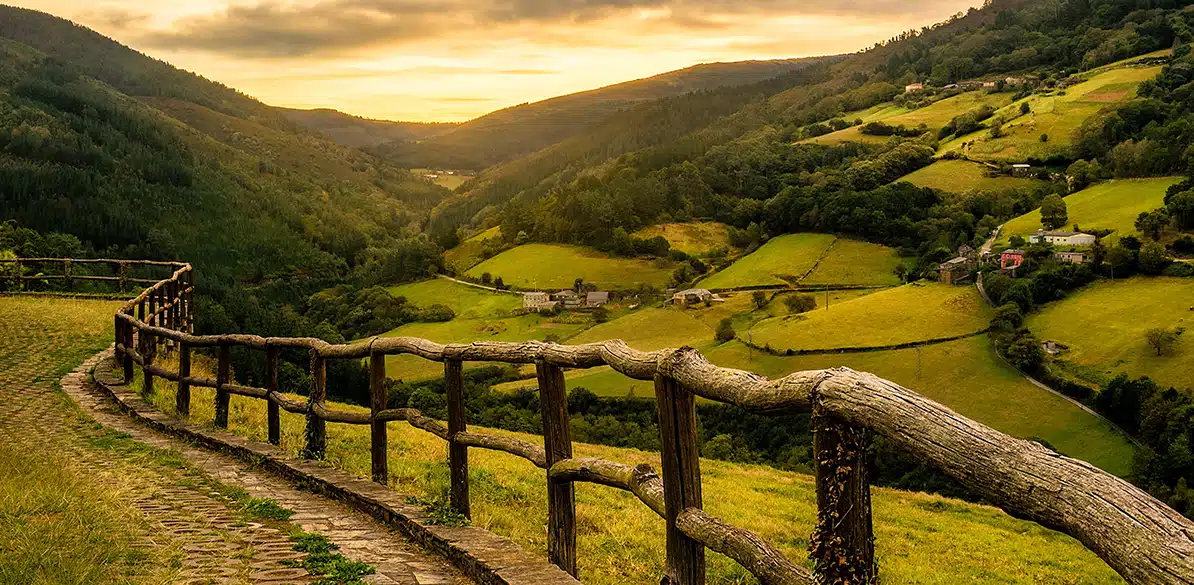 Asturias A green valley with wooden fences at sunset in the rural countryside of Asturias