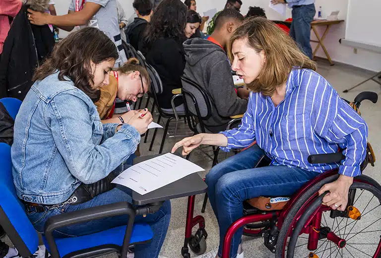 Mujer en silla de ruedas participando en una actividad con jóvenes