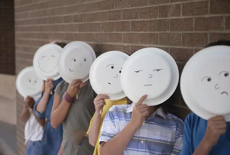 Grupo de niños con máscaras hechas a mano en clase